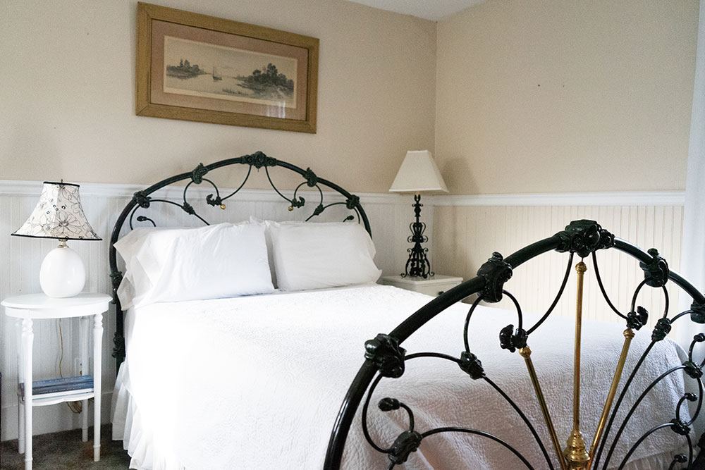 Diana Room with iron bedstead, white bedding and two bedside lamps